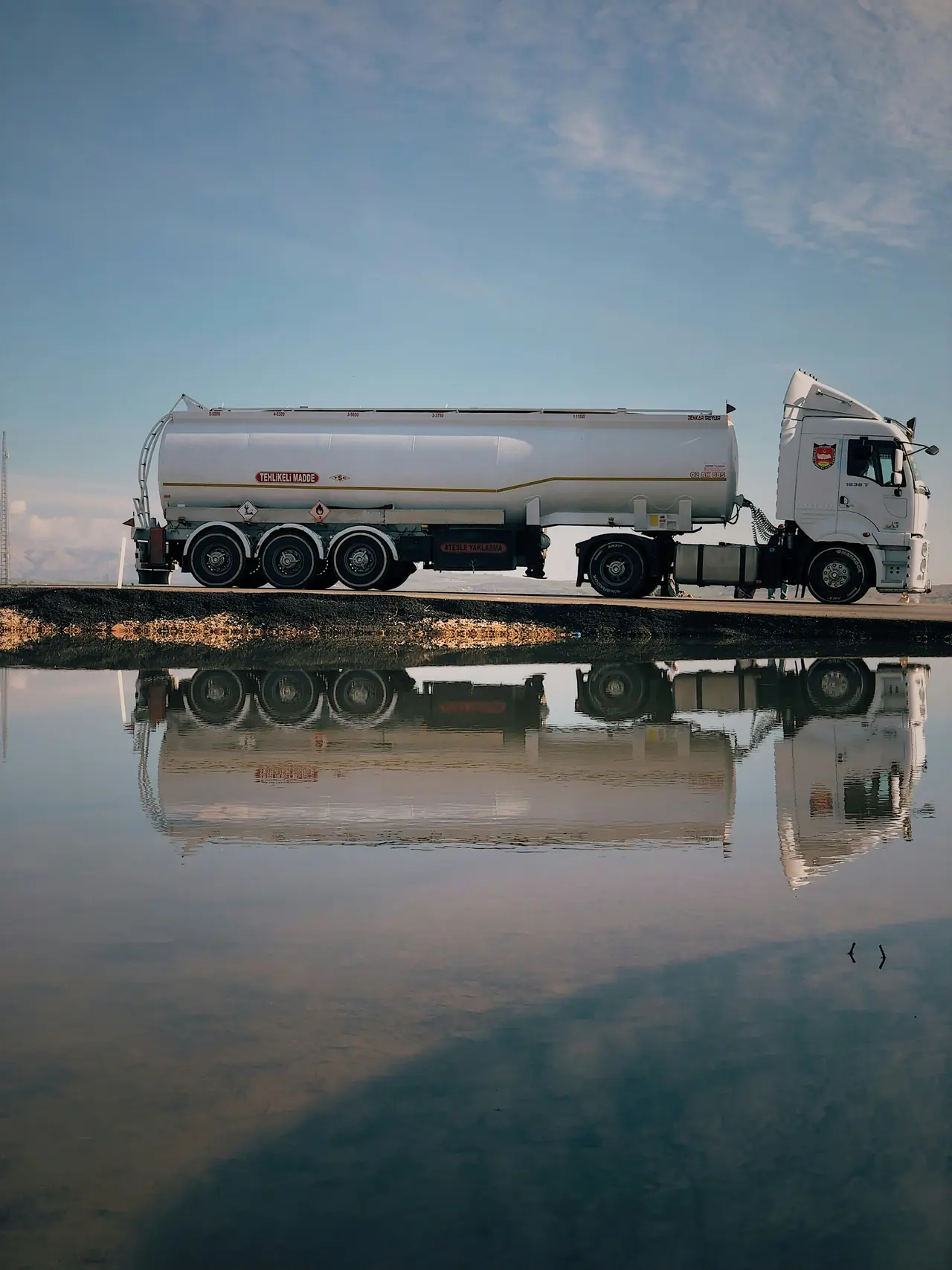 Fuel tanker truck beside still water